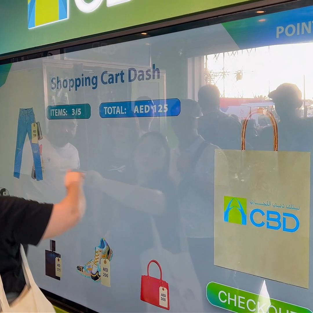 People playing a multi-level interactive financial literacy game at a brand activation event in Dubai, learning how to save and invest money.